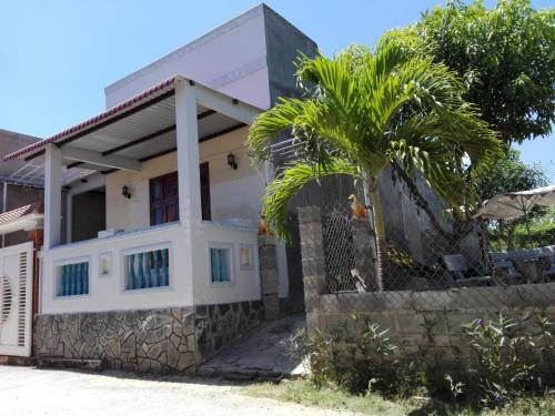 a house with a palm tree in front of it at The House 17/1 in Mui Ne