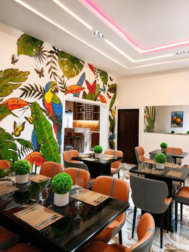 un ristorante con tavoli e sedie e una parete colorata di TOMA Hotel a Uyo