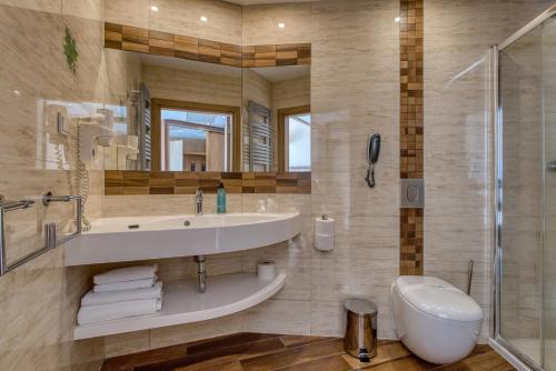 a bathroom with a sink and a shower and a toilet at Hotel Unitral SPA w Mielnie in Mielno