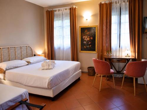 a bedroom with two beds and a table and chairs at Hotel Sor Paolo in San Casciano in Val di Pesa