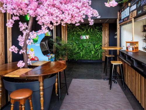 里摩日Greet Hotel Limoges Nord的酒吧天花板上悬挂着粉红色的花朵。