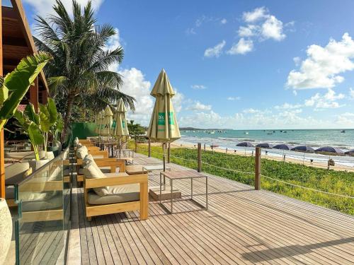 a row of chairs and umbrellas on a beach at Ibis Styles Maragogi in Maragogi