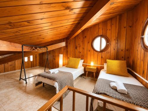 two beds in a room with wooden walls at El Molino Agaete in Puerto de las Nieves