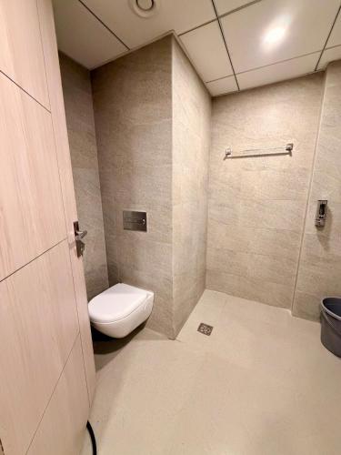 a bathroom with a toilet and a shower at R&R Eleanor Suites in Greater Noida