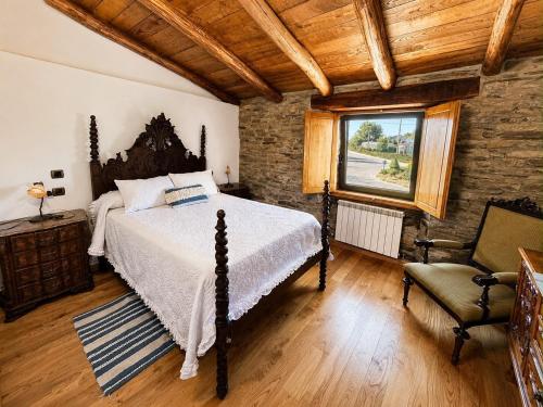 a bedroom with a bed and a window and a chair at Casa de Aira Padron 