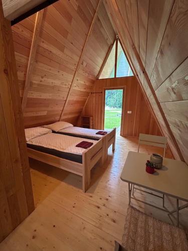 a bedroom with a bed in a wooden house at Glamping cabins in Gorenja Vas