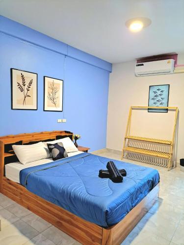 a bedroom with a large bed with a blue wall at The cabana guesthouse in Cha Am