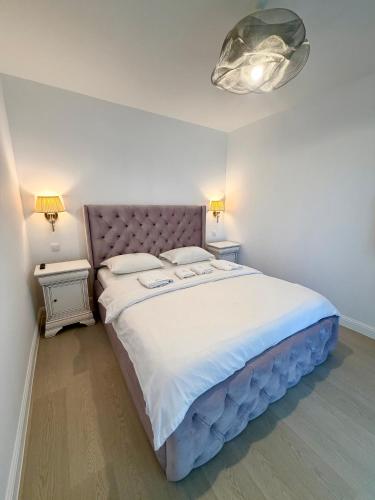 a bedroom with a large bed with white sheets and pillows at Apartament Amaya in Bistriţa