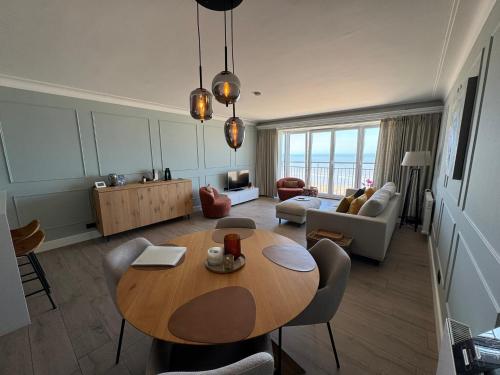 a living room with a wooden table and a living room at Sand & Sea - Adults Only in Middelkerke