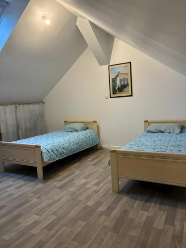 a room with two beds in a attic at Maison « La grange » climatisée in Azay-le-Rideau