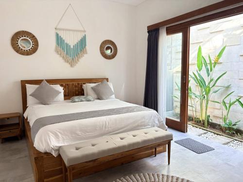 a bedroom with a large bed and a window at Amy Guesthouse Nusa Dua in Nusa Dua