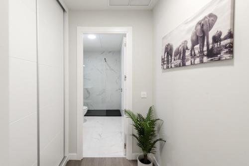 a bathroom with a toilet and a painting on the wall at Torrejón Suites 2 in Torrejón de Ardoz