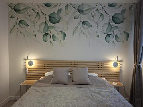 a bedroom with a bed with a flower mural on the wall at Hôtel Montespan in Lussac-les-Châteaux