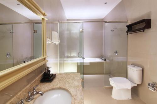 a bathroom with a sink and a shower and a toilet at Java Villas Boutique Hotel & Resto in Yogyakarta