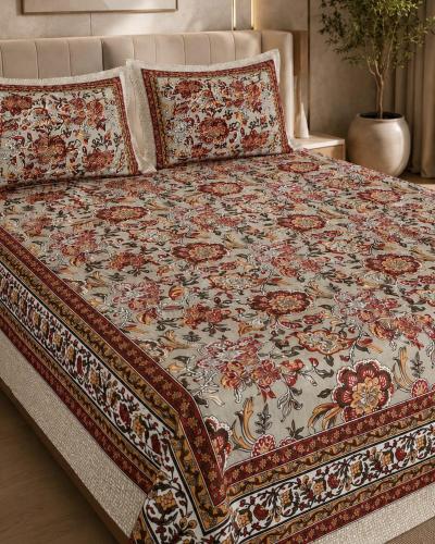 a bed with a flowered comforter on it at Hotel Lomontreey in Kākori