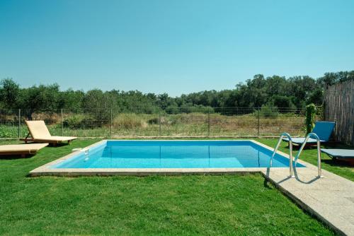 a swimming pool in a yard with a chair at Dimitras Home in Lefkimmi