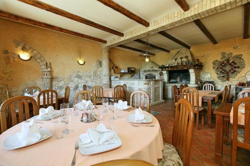 a dining room with tables and chairs and a kitchen at Sobe ROOMS TEA in Buje