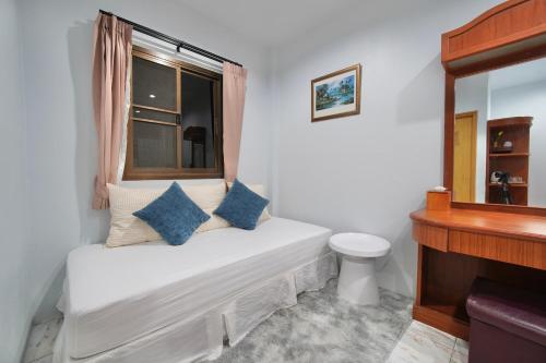 a small white room with a window and a toilet at Khun Ying House in Ko Tao