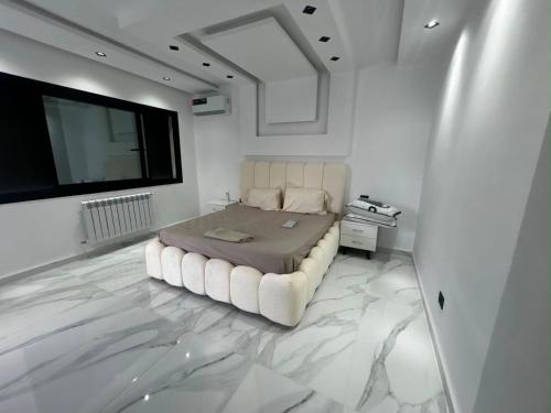 a bedroom with a large bed and a flat screen tv at Villa Zahra in Bizerte