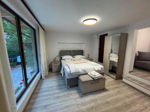a bedroom with a bed and a large window at Casa Crina in Băile Herculane