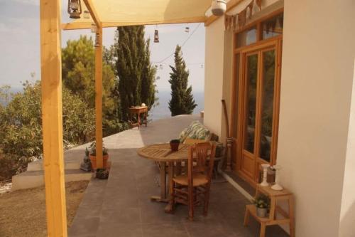 a patio with a wooden table and chairs and an umbrella at Casa luz Vista Verde Appartment in Polopos