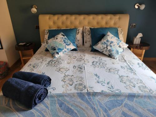 a bed with blue and white sheets and pillows at The Blue Gem in Acqui Terme
