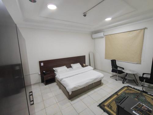 a bedroom with a bed and a projection screen at فندق فاديه الذهبي in ‘Ushayrah