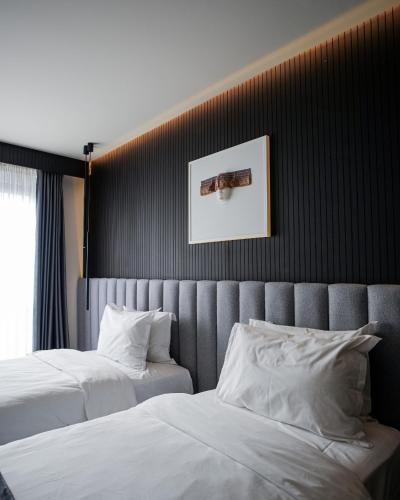 a bedroom with two beds and a picture on the wall at Derand Hotel in Prishtinë