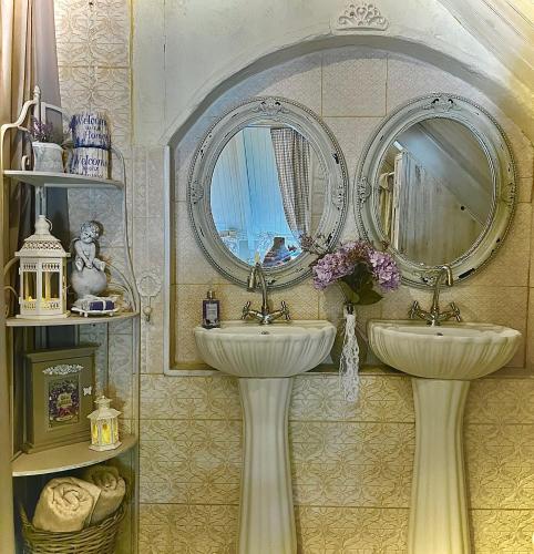 a bathroom with two sinks and a mirror at La Porte Bleue le grenier des Anges in Saint-Pierre