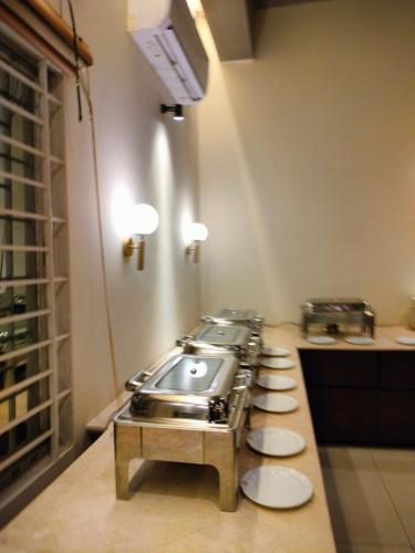 a kitchen with a stove and a row of sinks at Grand Khalifa Hotel Hamama in Sylhet