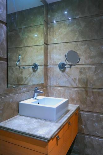 a bathroom with a sink and a mirror at Middleton Inn in Kolkata
