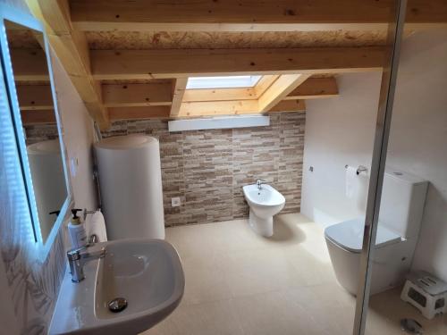 a bathroom with a white toilet and a sink at Vaniria 4 Apartamentos Nuevos in Foz