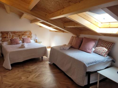 a attic room with two beds and a skylight at Vaniria 4 Apartamentos Nuevos in Foz