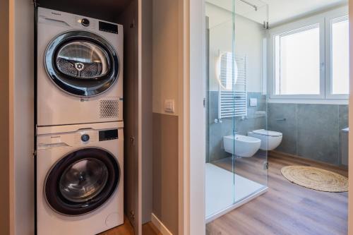 a washer and dryer in a bathroom with a shower at The Circle Bike Residence by Rent All Como in Tavernerio