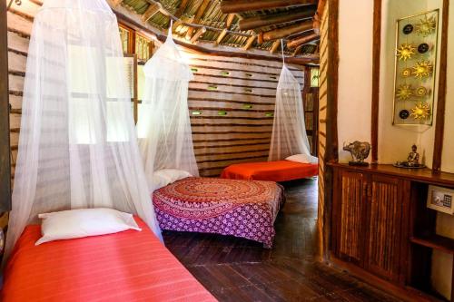ein Zimmer mit zwei Betten und Vorhängen in einem Haus in der Unterkunft 2 Family Comfort Rooms with Terrace - Luna Tierra in Cumaral