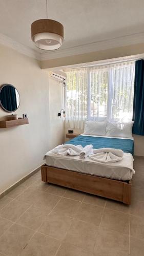 a bedroom with a large bed with a window at Minikbiotel in Erdek