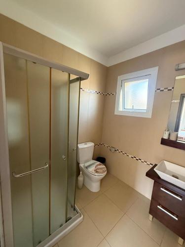 a bathroom with a toilet and a glass shower at Villa Flory in Protaras