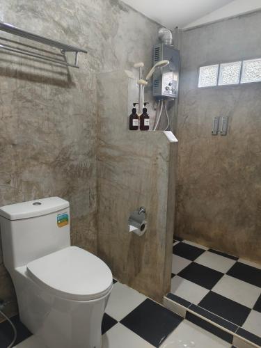 a bathroom with a toilet and a checkered floor at สวนฉัน Igarden in Ban Pang Champi