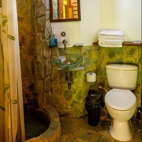 Ein Steinbadezimmer mit Toilette und Waschbecken in der Unterkunft 2 Family Comfort Rooms with Terrace - Luna Tierra in Cumaral