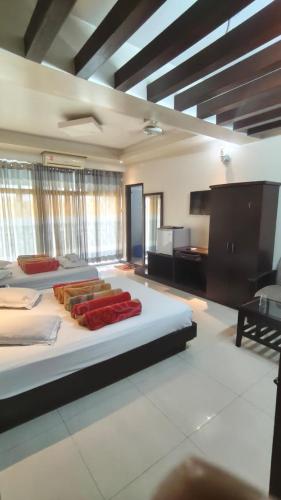 ein großes Schlafzimmer mit zwei Betten und einem Schreibtisch in der Unterkunft Well Park Resort in Cox's Bazar