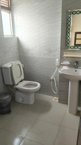 ein Badezimmer mit Toilette und Waschbecken in der Unterkunft Well Park Resort in Cox's Bazar