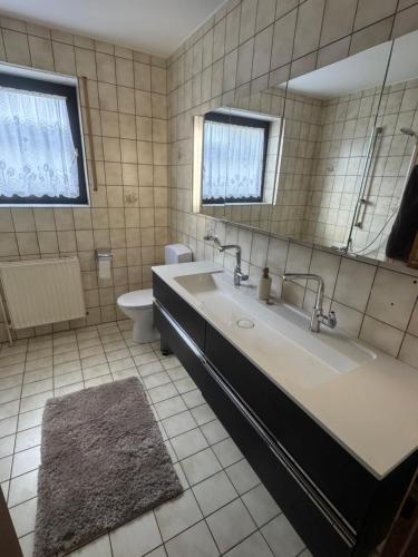 a bathroom with a tub and a toilet and a mirror at HabichtsNest Stockum in Sundern