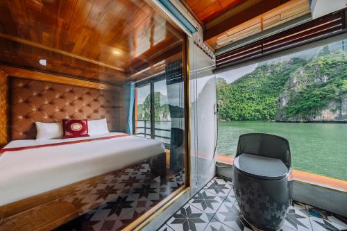 a bedroom on a boat with a bed and a chair at Vietnam Venture Cruises in Cat Ba