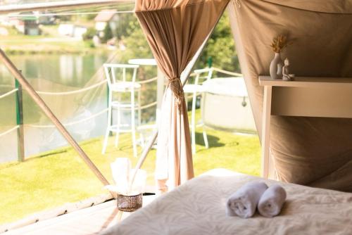 a newborn baby laying on a bed in front of a window at Drivibe Glamping, Goražde in Goražde