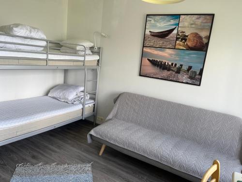a bedroom with two bunk beds and a couch at Kumpukuja apartment in Kouvola
