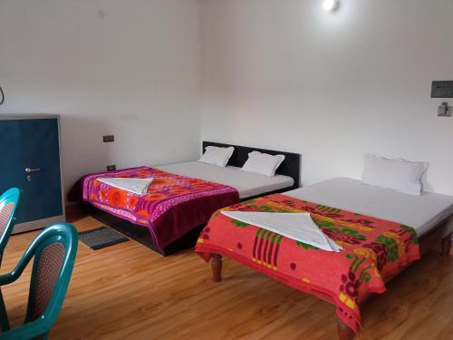 a room with two beds and a chair at BBL Resort in Bokākhāt