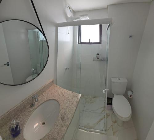a bathroom with a sink and a mirror and a toilet at Apartamento Crisalidas em Foz in Foz do Iguaçu