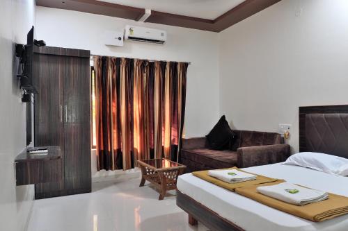 a hotel room with a bed and a couch at Betel Leaf Resort in Māhīm