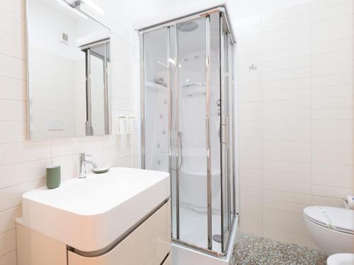 a white bathroom with a sink and a shower at Dadu 14 in Bari