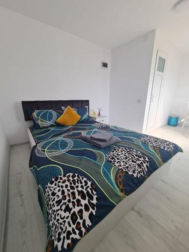 a bed with a colorful comforter and pillows on it at Ferma DAC in Galaţi